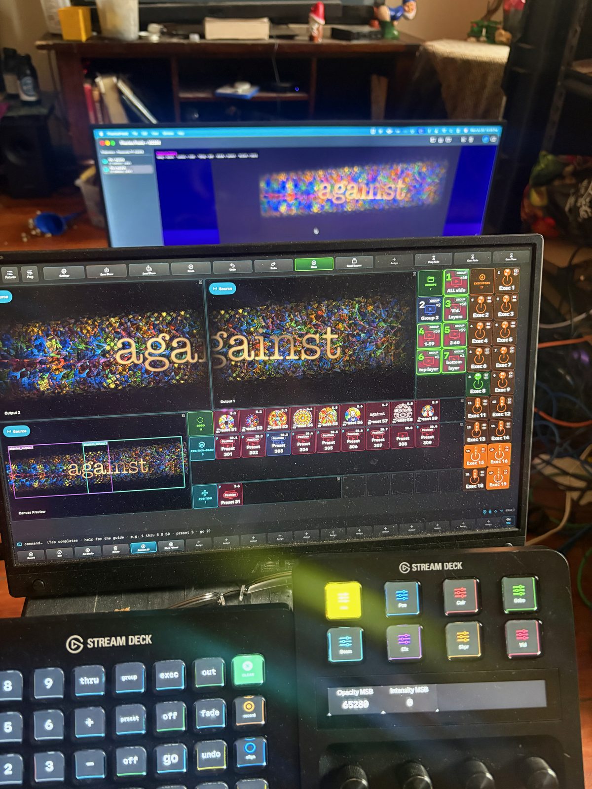 A front-of-house desk running Phantos: laptop, two Stream Deck control surfaces and a monitor, mid-show